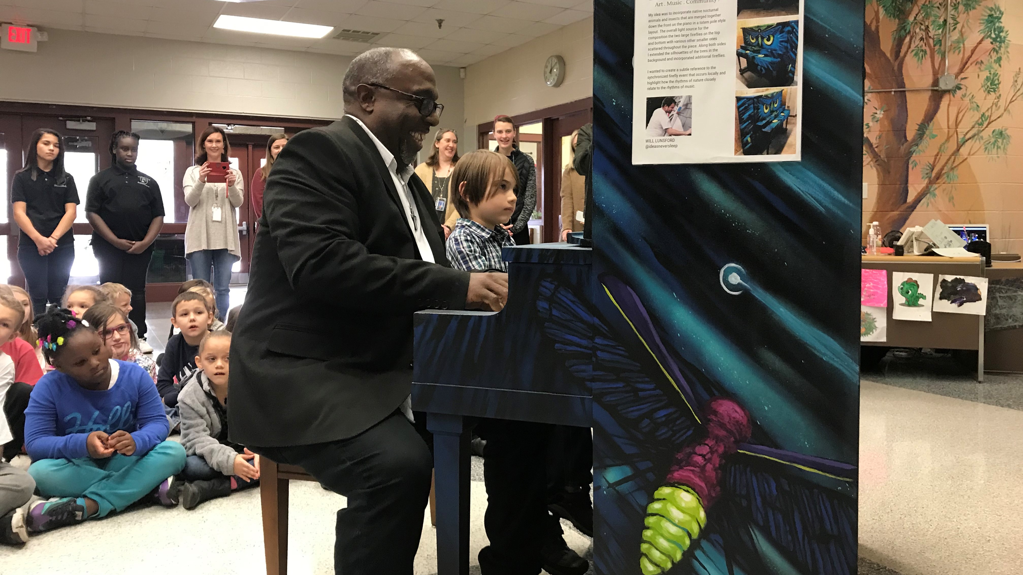 Brian Clay plays a duet with Dogwood Elementary student Aurelio Ilagan during a ceremony on Nov. 26, 2019. 